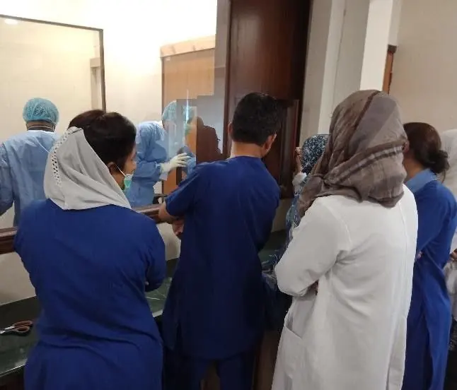 Nursing staff and a LabLink specialist reviewing a medical device