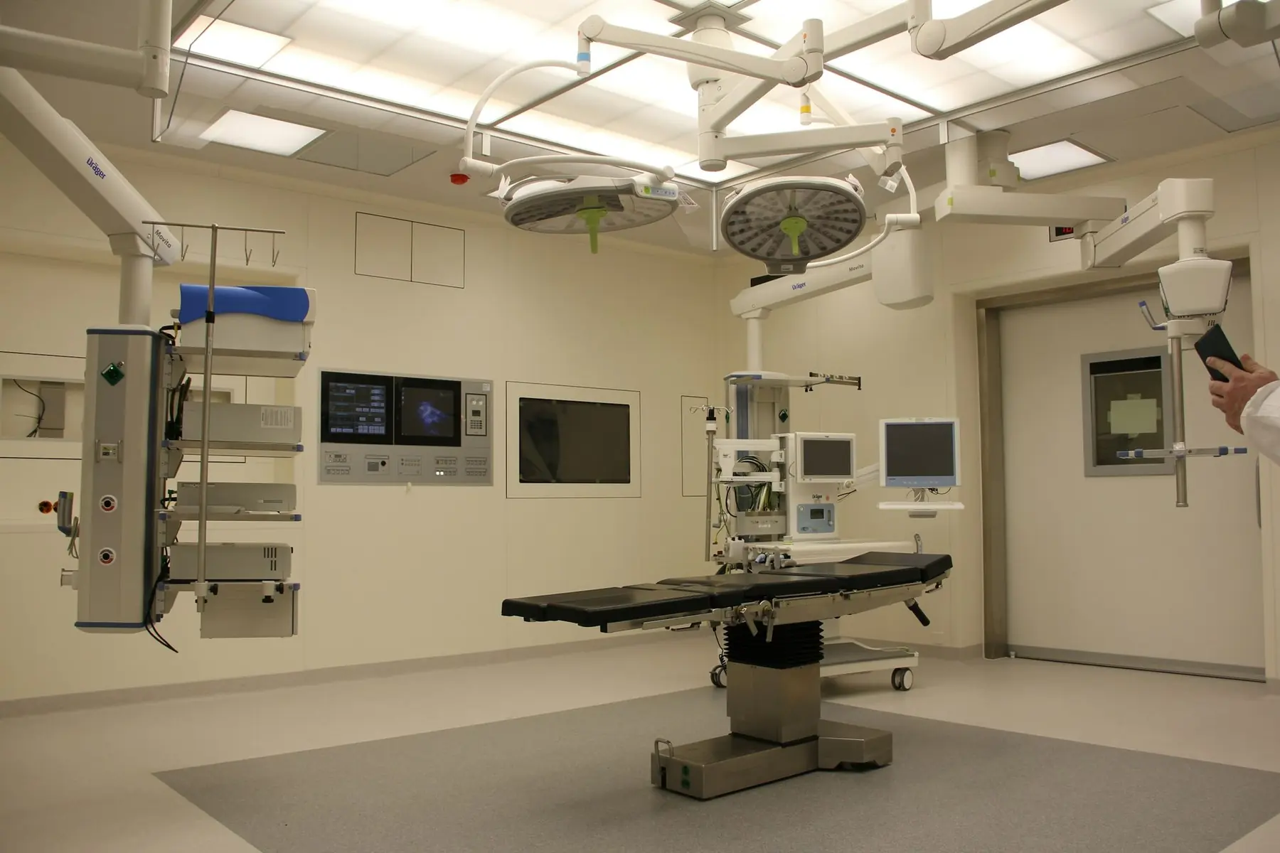 A modern hospital operating theatre equipped with surgical lights, monitors and anaesthesia equipment