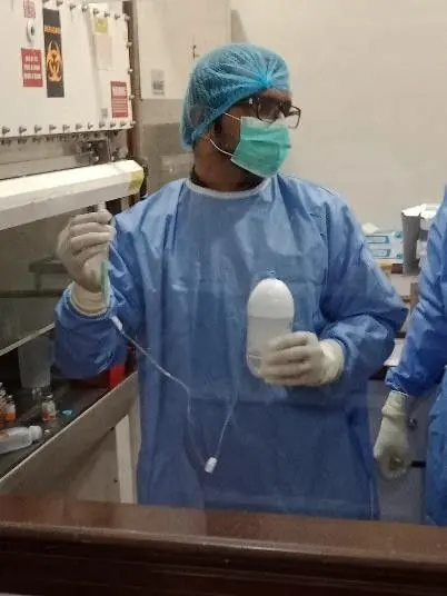 Laboratory staff in protective gowns at a biosafety cabinet